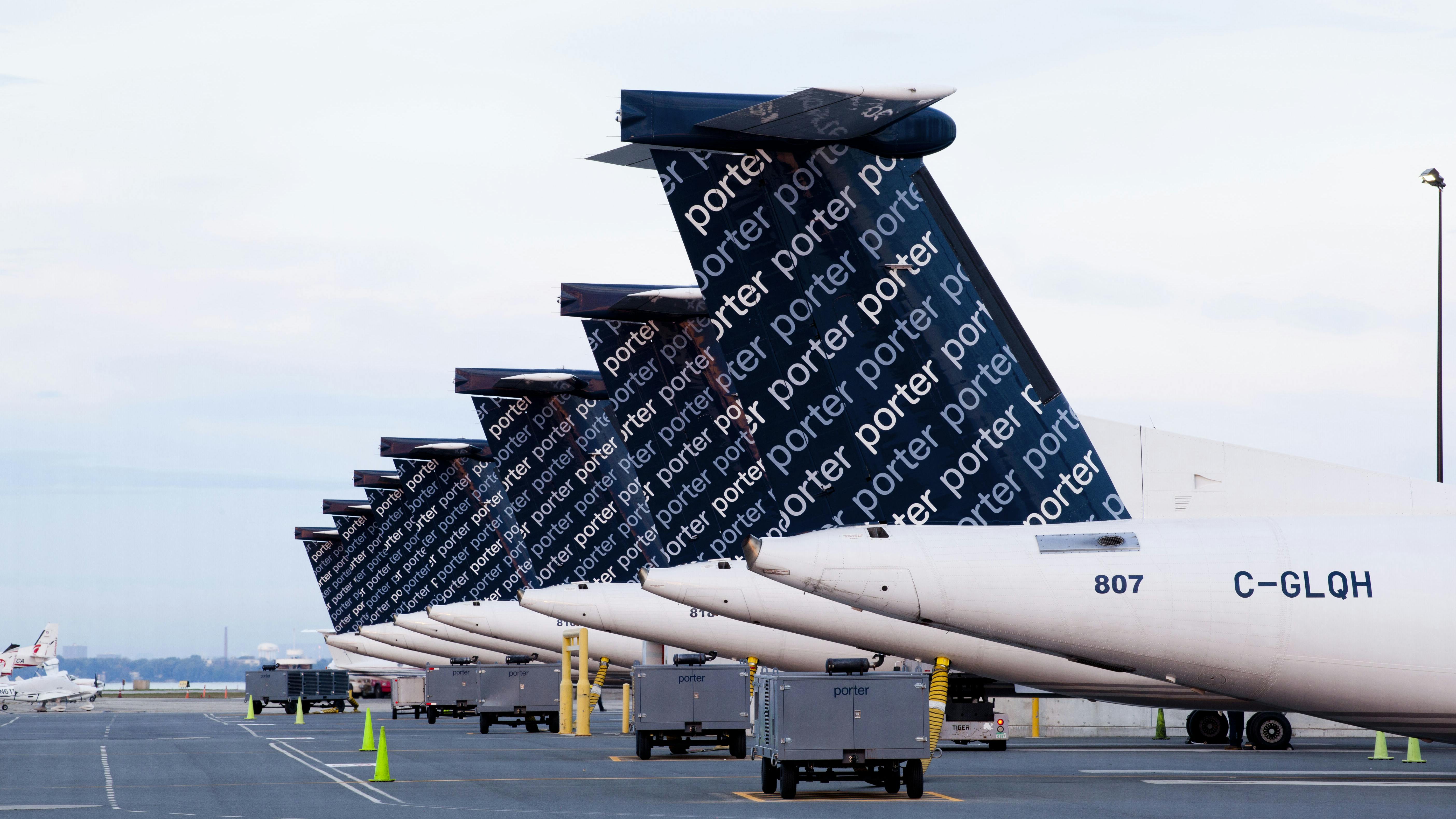 A row of airplanes parked on a tarmac with the word 'Porter' repeated in a decorative pattern on the back of each plane
