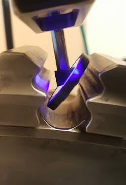 A piece of technological equipment taking close measurements of a curvy piece of metal A piece of technological equipment taking close measurements of a curvy piece of metal