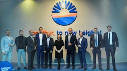 A group of professionals in business attire smiling at the camera and standing in front of a sign that reads: Together, to new heights A group of professionals in business attire smiling at the camera and standing in front of a sign that reads: Together, to new heights