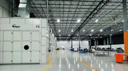 The interior of a maintenance hangar with large storage containers to the left and worktables and equipment to the right