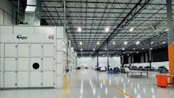 The interior of a maintenance hangar with large storage containers to the left and worktables and equipment to the right The interior of a maintenance hangar with large storage containers to the left and worktables and equipment to the right