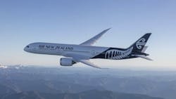 A white airplane with decorative designs on the tail and text on the side that reads: Air New Zealand A white airplane with decorative designs on the tail and text on the side that reads: Air New Zealand