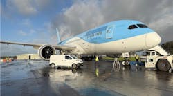 A white and blue airplane parked on a tarmac with a white van parked next to it on the ground A white and blue airplane parked on a tarmac with a white van parked next to it on the ground
