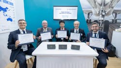 A group of men wearing suits sitting at a table and holding up framed certificates while smiling at the camera A group of men wearing suits sitting at a table and holding up framed certificates while smiling at the camera