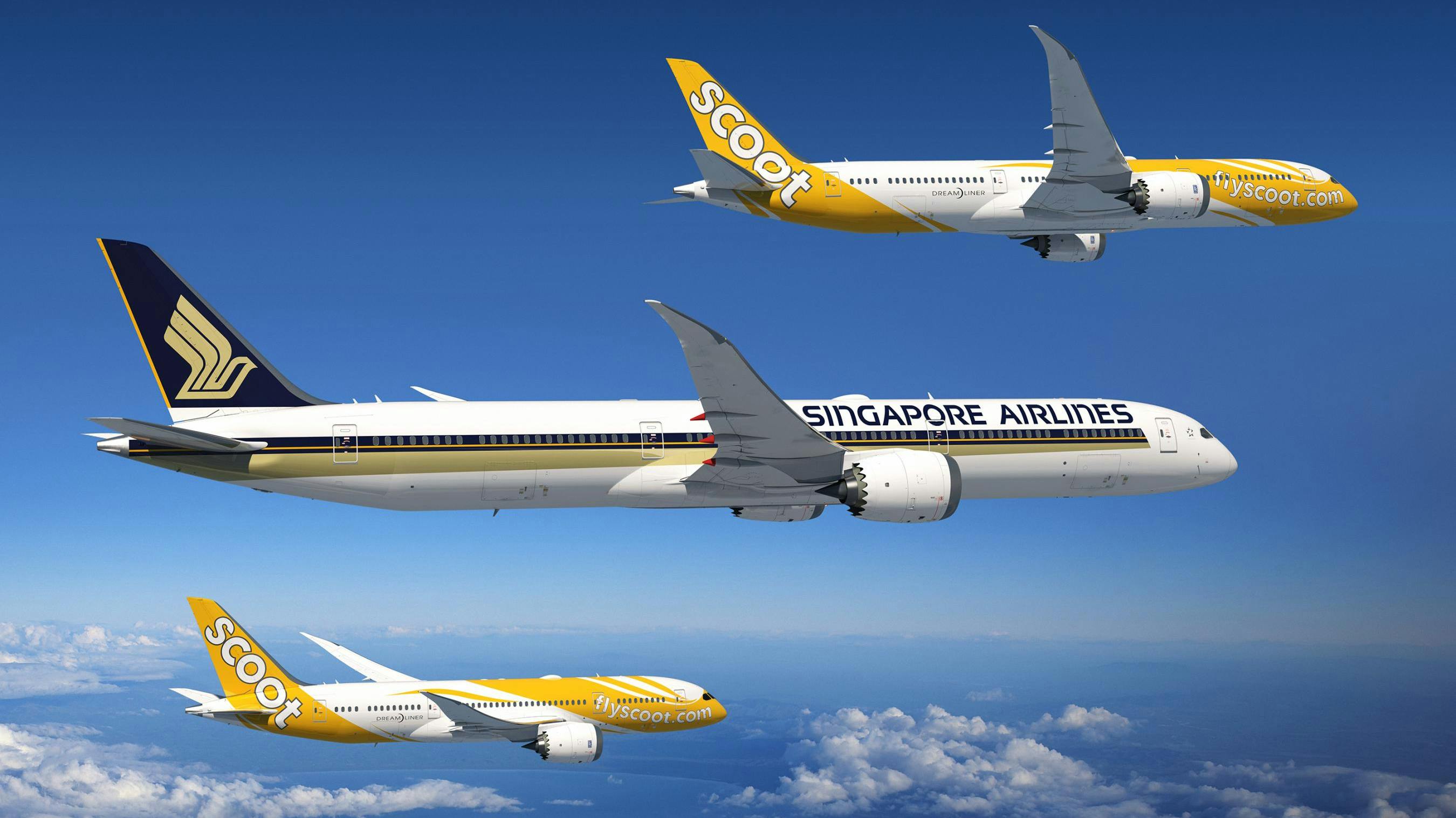 Three airplanes in the sky decorated in white, black, and yellow livery with one plane showing the text, 'Singapore Airlines' and the other two showing the text, 'SCOOT'