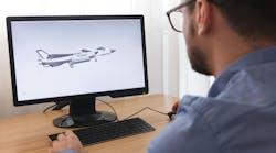 A man looking at a desktop computer that's displaying a 3D digital rendering of an airplane A man looking at a desktop computer that's displaying a 3D digital rendering of an airplane