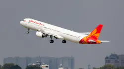 A white airplane with a red and orange tail with text on the side that reads: Sun PhuQuoc Airways