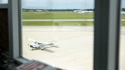 A view through a window of a white airplane parked on a tarmac A view through a window of a white airplane parked on a tarmac