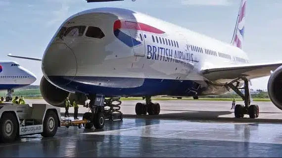 A white airplane with a blue bottom and red and blue accents that says, 'British Airways' on the side