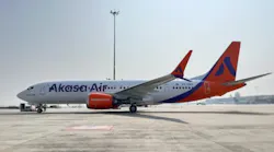 A white airplane with red accents on the tail and wings and text printed on the side that reads: Akasa Air