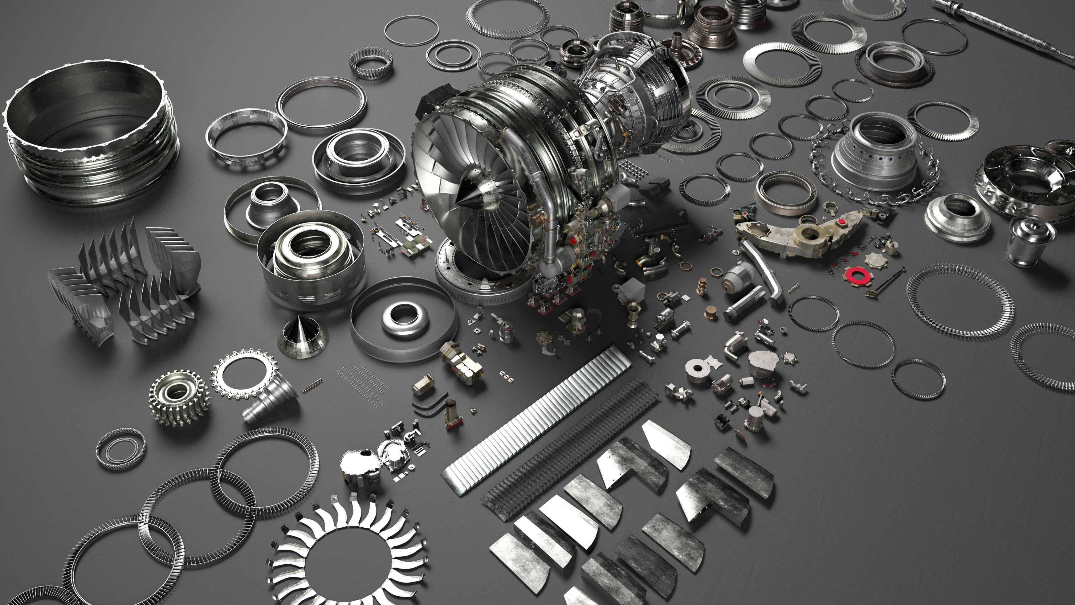 An array of metal airplane parts scattered on a gray surface