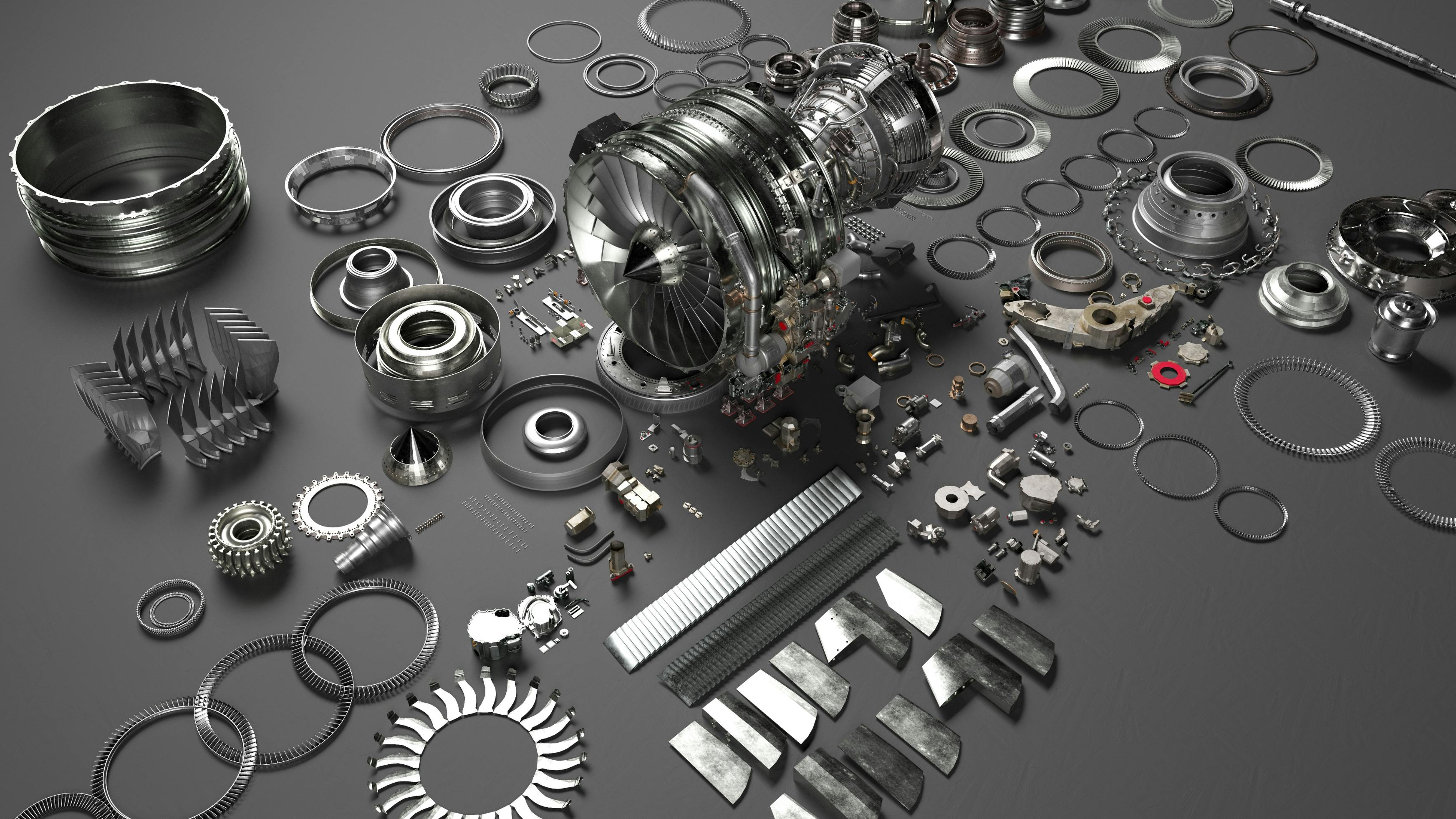 An array of metal airplane parts scattered on a dark gray surface