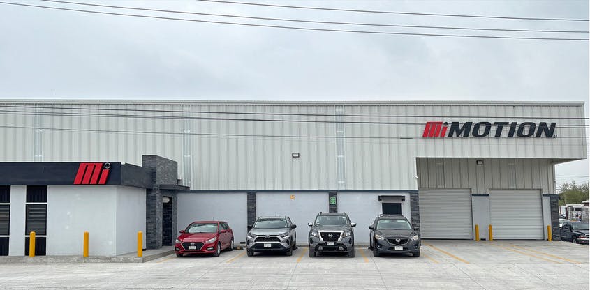 A white building with a sign on the front that reads 'MOTION' with a red 'M' logo next to it