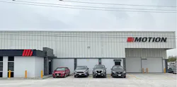 A white building with a sign on the front that reads 'MOTION' with a red 'M' logo next to it