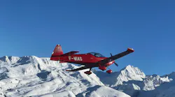 A red airplane flying over snowy mountains