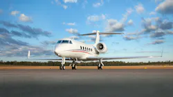 A white airplane with red and green stripes on the side parked on a tarmac outdoors with a blue sky behind it A white airplane with red and green stripes on the side parked on a tarmac outdoors with a blue sky behind it