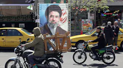 Two people riding bikes in the street of a city with businesses behind them Two people riding bikes in the street of a city with businesses behind them