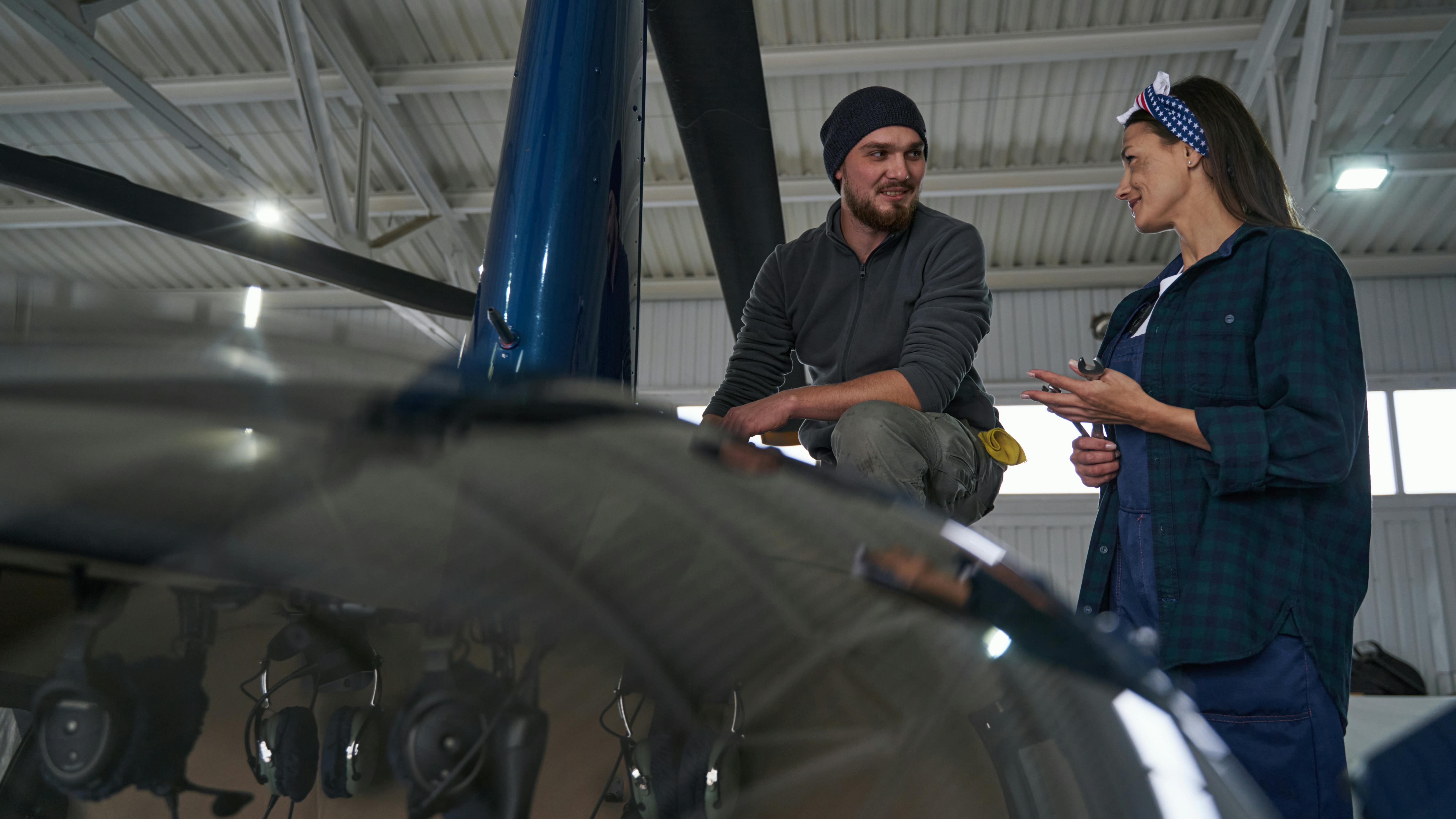 Two aircraft technicians talking while working on an airplane