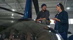 Two aircraft technicians talking while working on an airplane Two aircraft technicians talking while working on an airplane