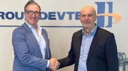 Two men wearing business attire shaking hands and smiling at the camera Two men wearing business attire shaking hands and smiling at the camera