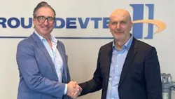 Two men wearing business attire shaking hands and smiling at the camera Two men wearing business attire shaking hands and smiling at the camera