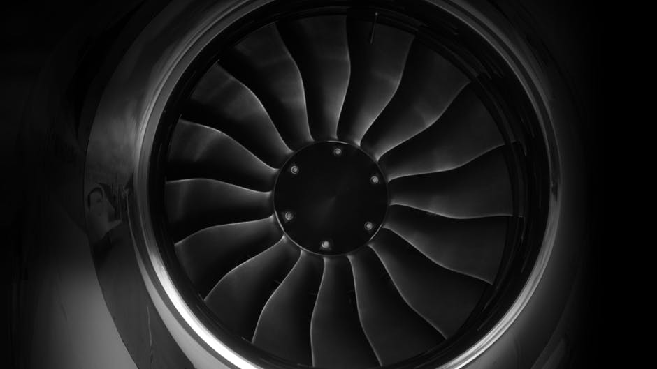 A close-up photograph of an airplane engine, focusing on its turbines