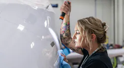 A woman holding a flashlight and inspecting an airplane up close A woman holding a flashlight and inspecting an airplane up close