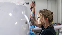 A woman holding a flashlight and inspecting an airplane up close A woman holding a flashlight and inspecting an airplane up close