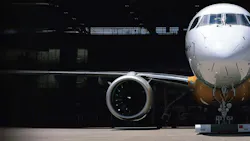 A photograph of a parked airplane, focusing on the engine A photograph of a parked airplane, focusing on the engine