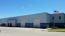 A large warehouse-type building with an American flag in front A large warehouse-type building with an American flag in front