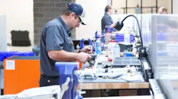 A technician at a work table repairing machinery components A technician at a work table repairing machinery components