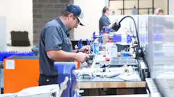A technician at a work table repairing machinery components A technician at a work table repairing machinery components