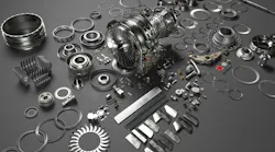 A collection of metal parts spread out on a gray surface A collection of metal parts spread out on a gray surface