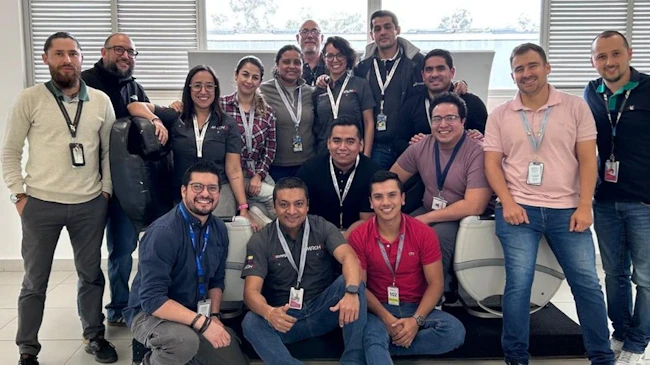 A large group of people wearing ID badges smiling at the camera