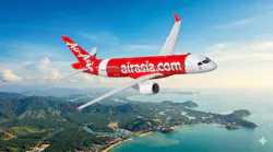A red and white airplane with 'AirAsia' and 'airasia.com' printed on the side flying above an island A red and white airplane with 'AirAsia' and 'airasia.com' printed on the side flying above an island