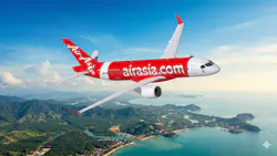 A red and white airplane with 'AirAsia' and 'airasia.com' printed on the side flying above an island A red and white airplane with 'AirAsia' and 'airasia.com' printed on the side flying above an island