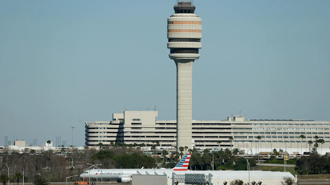 An American Airlines aircraft moves past the air traffic control tower at the Orlando International Airport, on Jan. 27, 2026. (Ricardo Ramirez Buxeda/Orlando Sentinel/TNS)