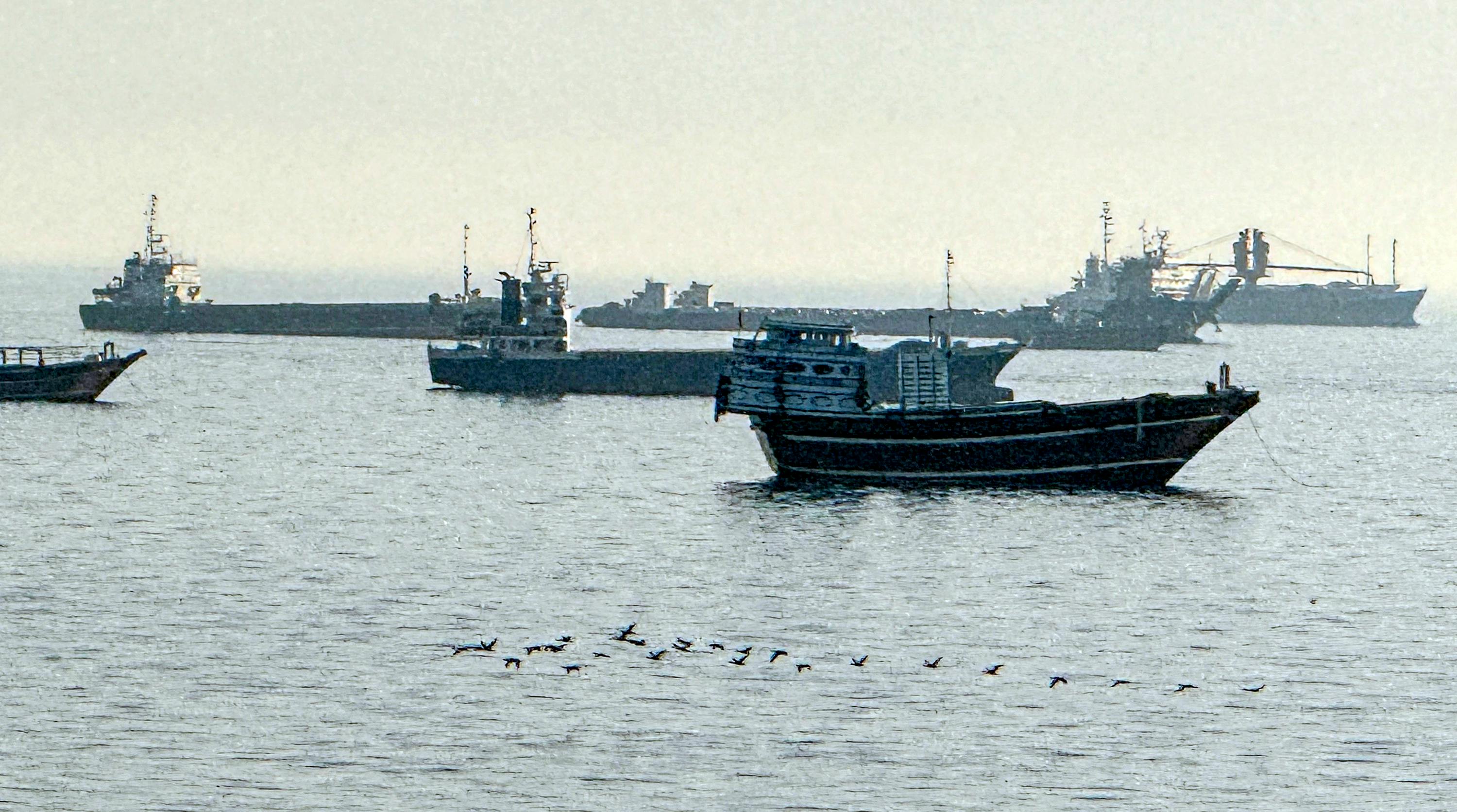 A group of military boats floating in water