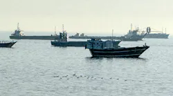 A group of military boats floating in water