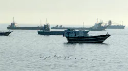 A group of military boats floating in water A group of military boats floating in water