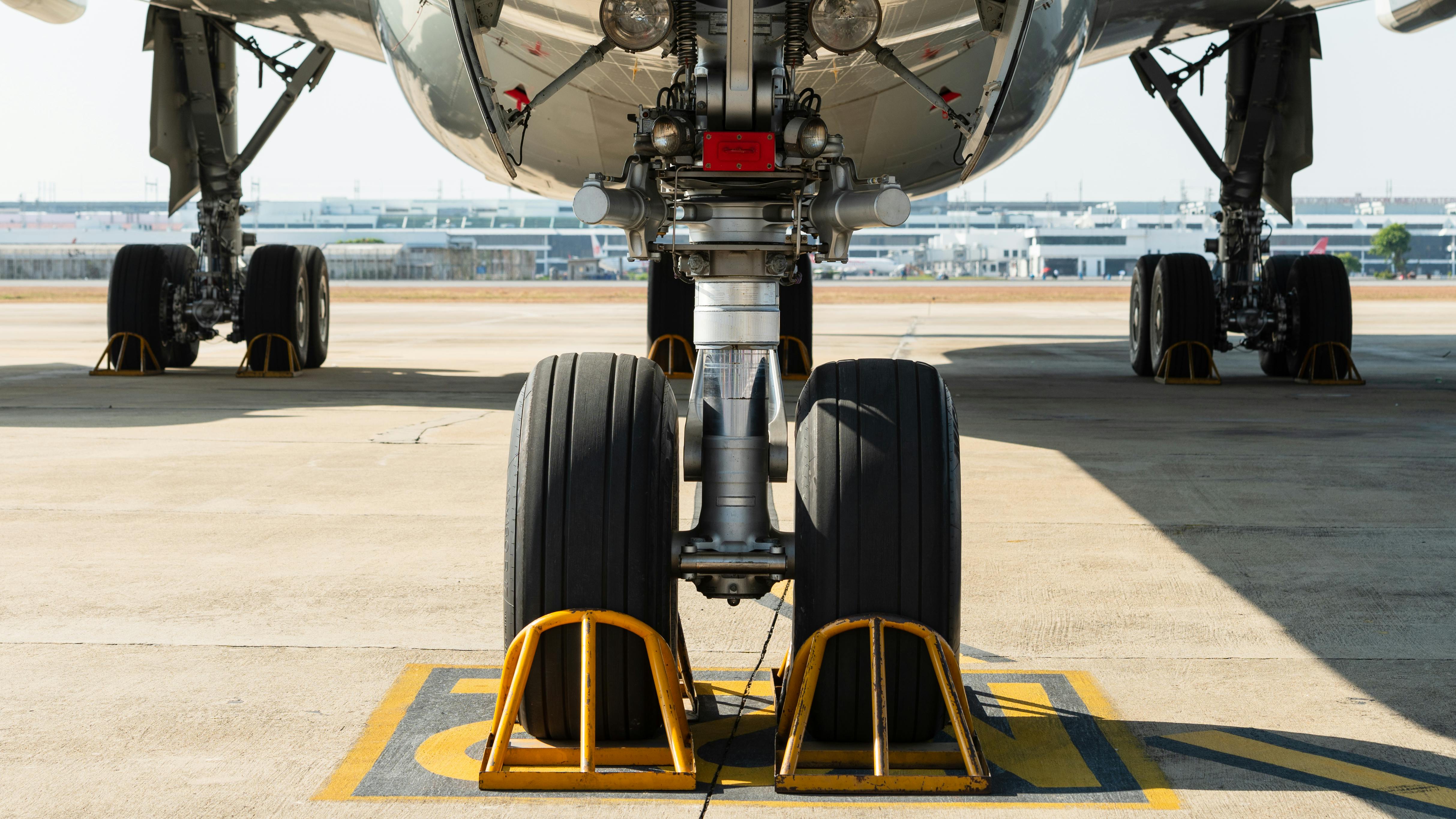 An airplane parked on a tarmac, with the camera zooming in on the tires