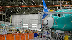 A wide shot of an aircraft production warehouse, with airplanes lined up among machinery A wide shot of an aircraft production warehouse, with airplanes lined up among machinery