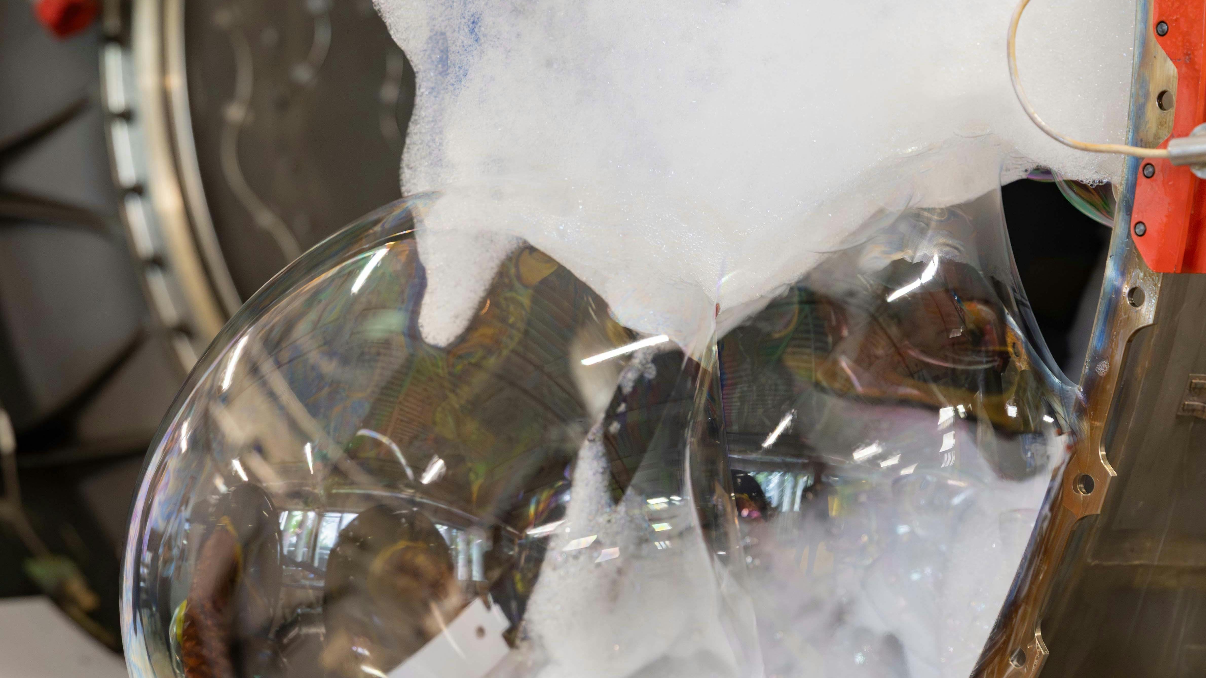 Soap bubbles and foam seeping out of an airplane engine, shown in a zoomed-in photograph