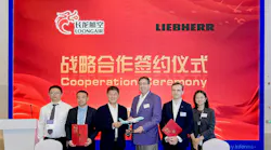 A line of people wearing business attire standing behind a table and holding paperwork while smiling at the camera in front of a backdrop that reads: Cooperation Ceremony Loong Air Liebherr