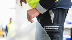A technician wearing pants with a patch that says, 'MAINTENANCE' holding a piece of clear film with riblets on it