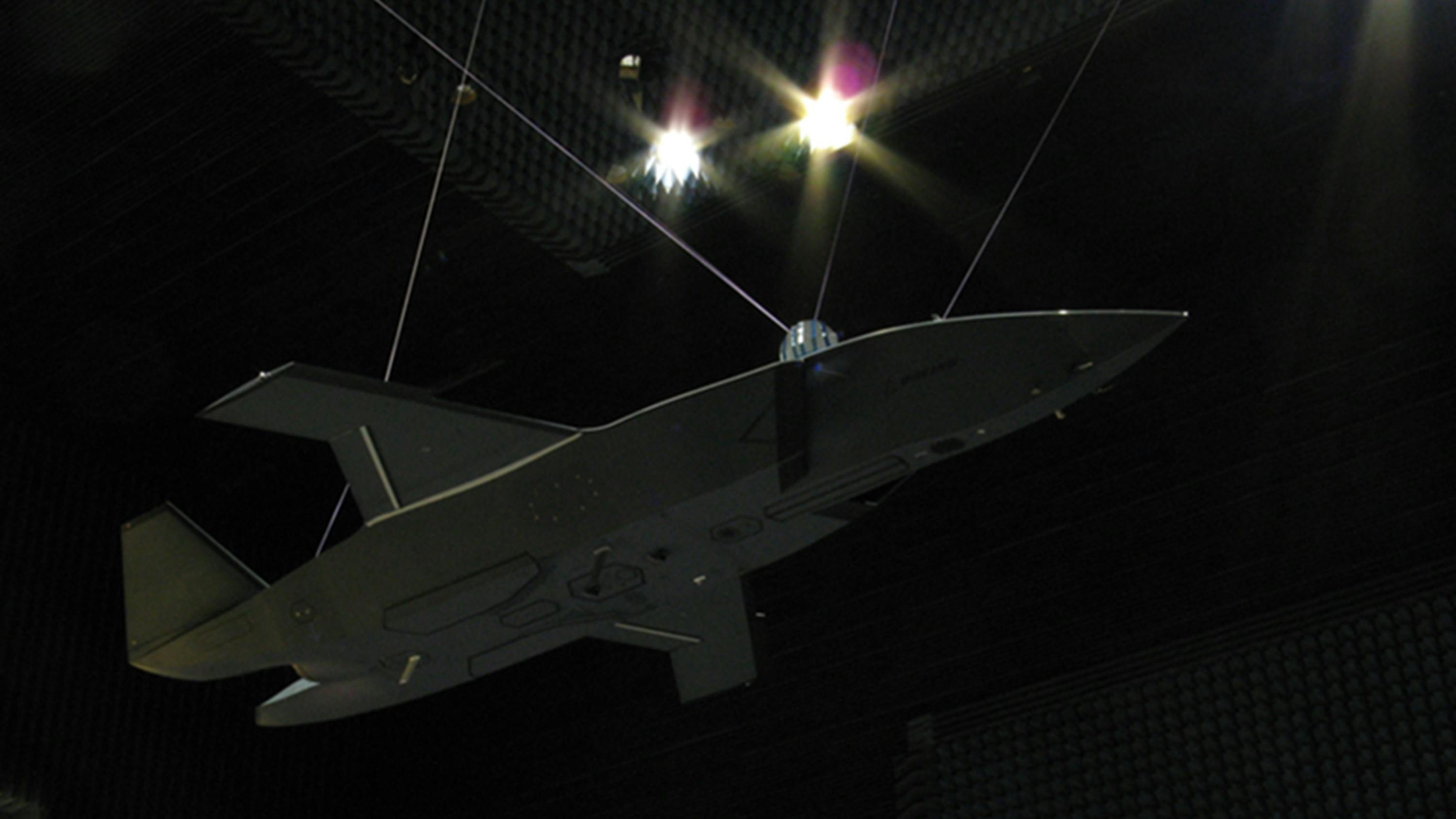 A military aircraft suspended in the air in a very dark area