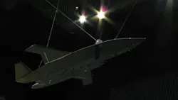A military aircraft suspended in the air in a very dark area A military aircraft suspended in the air in a very dark area