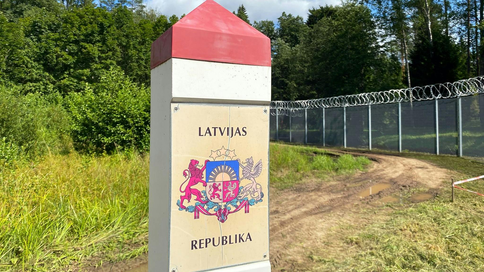 A border marking with a coat of arms and text that reads 'Latvijas Republika'