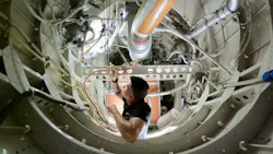 A technician working inside of an airplane engine A technician working inside of an airplane engine