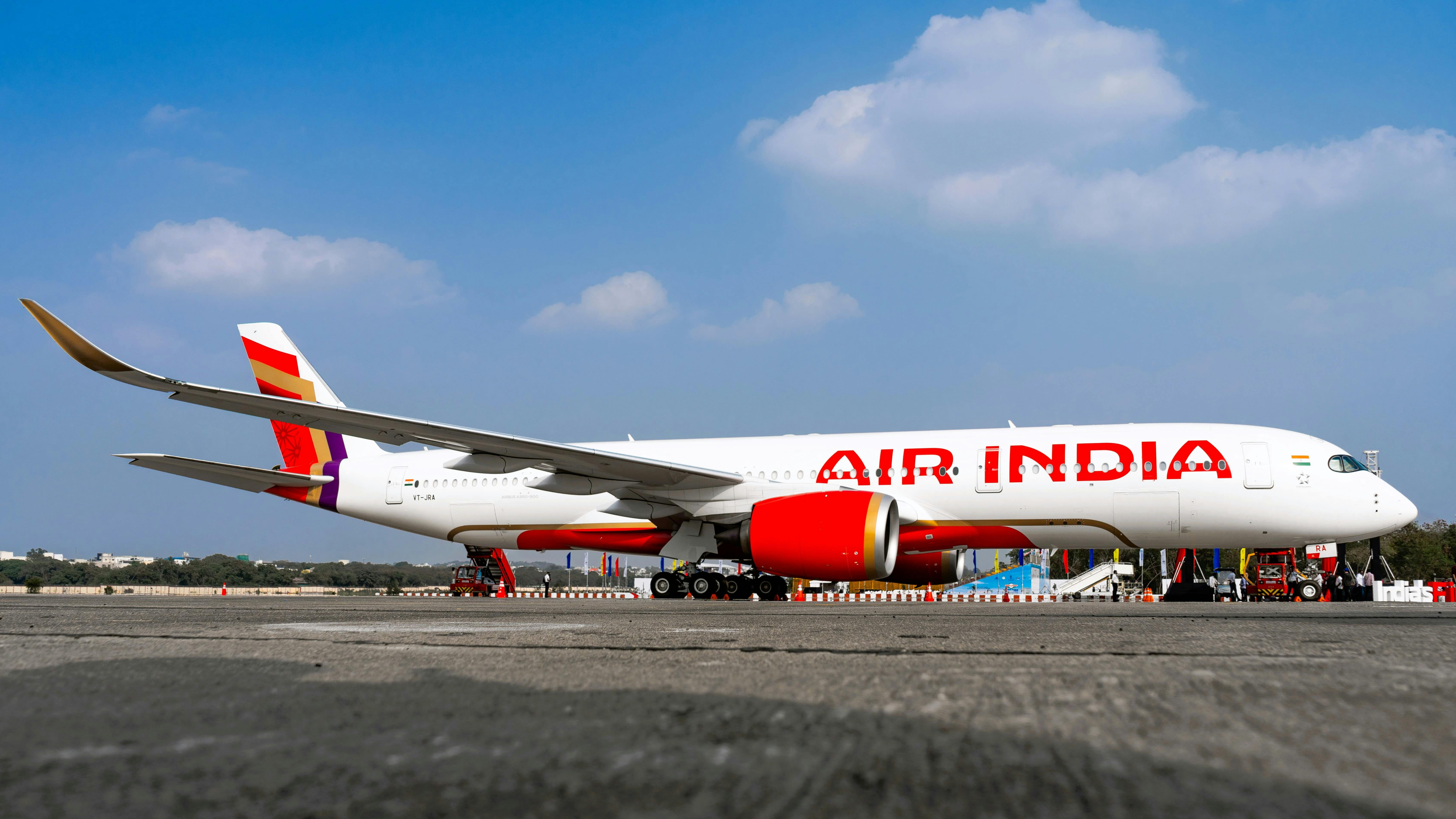 A white airplane with red accents and text on the side that reads: Air India